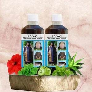 Here are some descriptive alt tags for the product image:

*   Two bottles of "Adivasi Herbal Hair Oil"
*   Hair oil bottles with before-and-after hair images.
*   Hair oil product with flower and plant decoration.
*   Bottles of hair care product on a wooden surface.
*   Brown and green-toned hair oil advertisement.