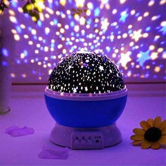 Blue star projector night light casting colorful star and dot patterns on purple wall