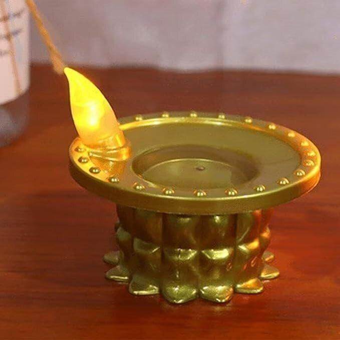 Golden LED water pouring diya light with lotus-shaped base on a wooden surface